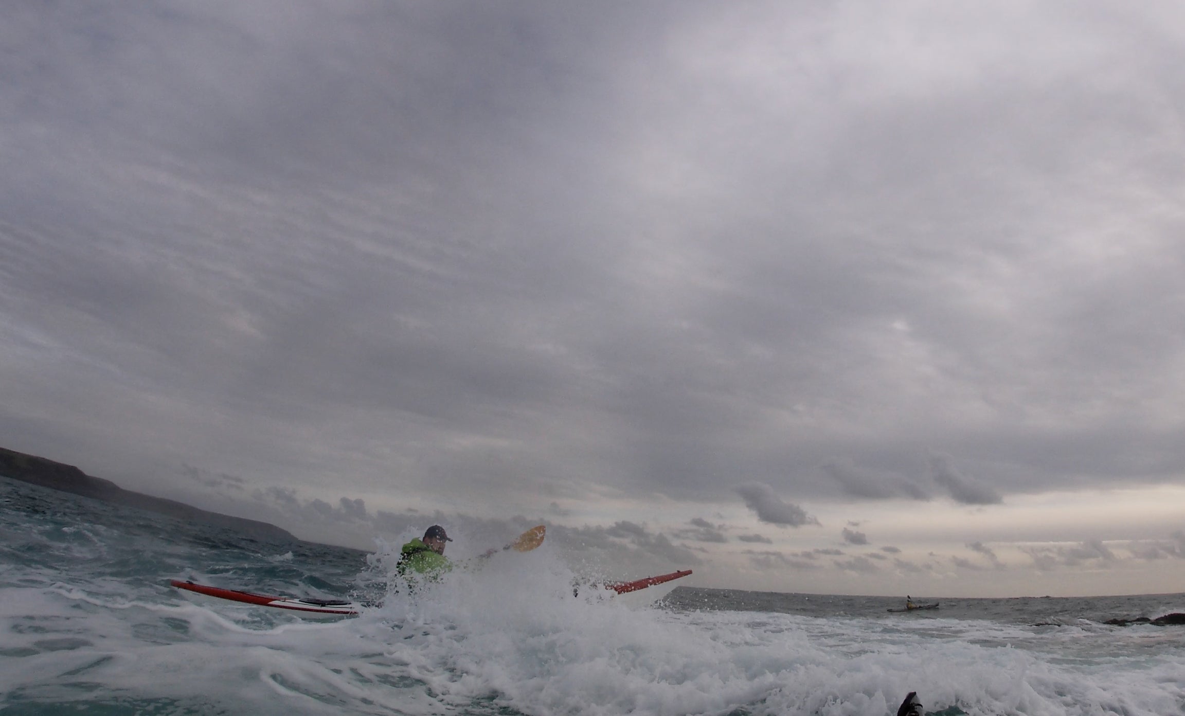 Staff Member Andrew punching through a wave using Corryvreckan 220 paddles off Gribbin Head